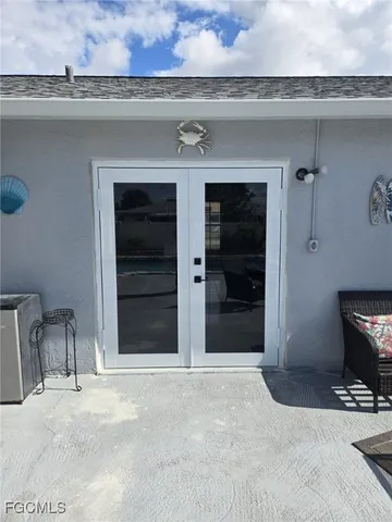 a view of a patio with table and chairs under an umbrella with a small yard