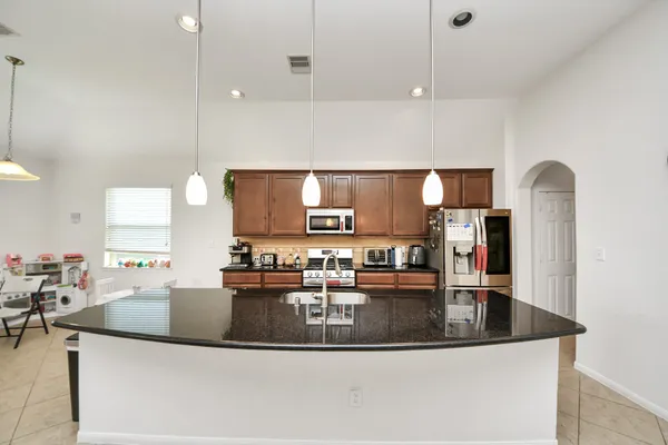 a kitchen with kitchen island a sink appliances and cabinets