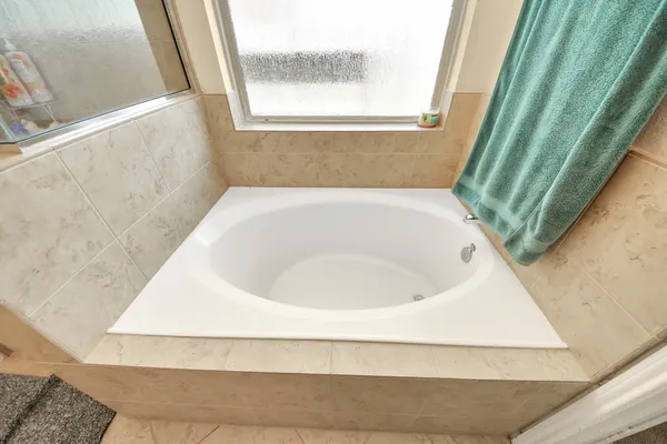 a bathroom with a tub shower and sink