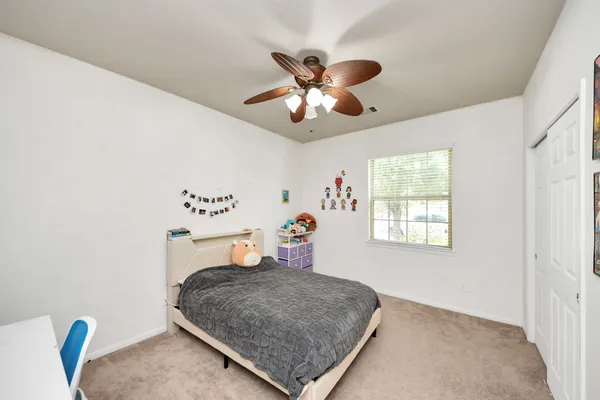 a bedroom with furniture and a chandelier fan
