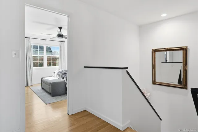 a view of a hallway with wooden floor and staircase