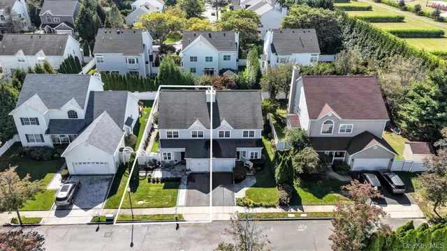 an aerial view of a house with a yard and a large tree