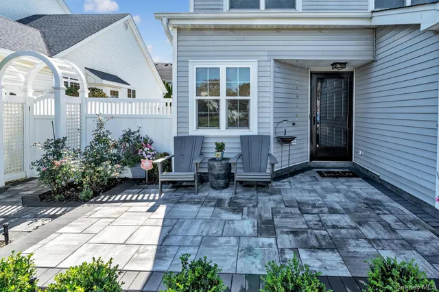 a front view of a house with chairs and potted plants