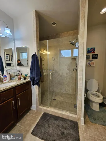 a bathroom with a granite countertop sink a toilet and shower