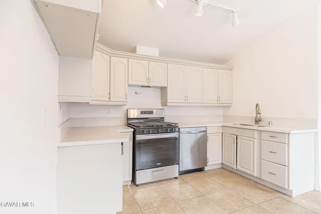 a kitchen with white cabinets and white appliances