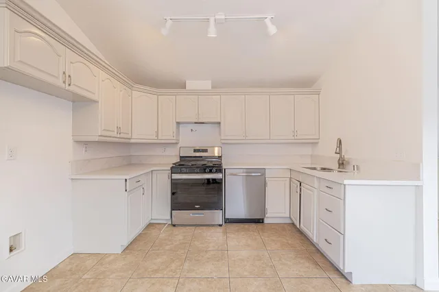 a kitchen with stainless steel appliances granite countertop a stove sink and cabinets
