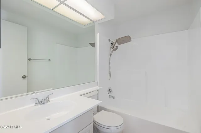 a bathroom with a toilet a sink a mirror and shower