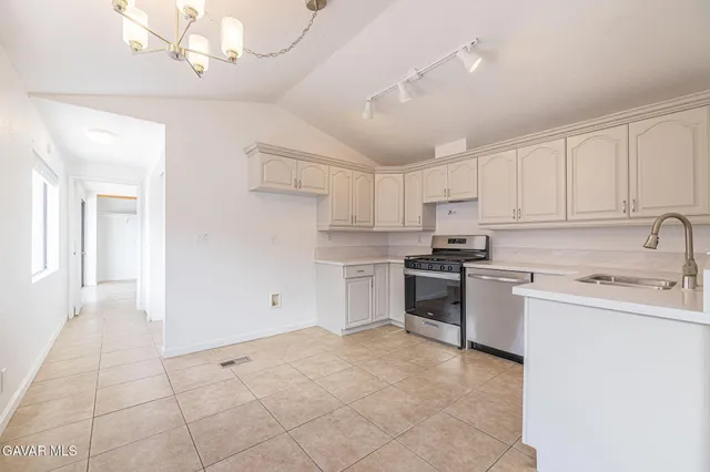 a kitchen with a stove sink and cabinets