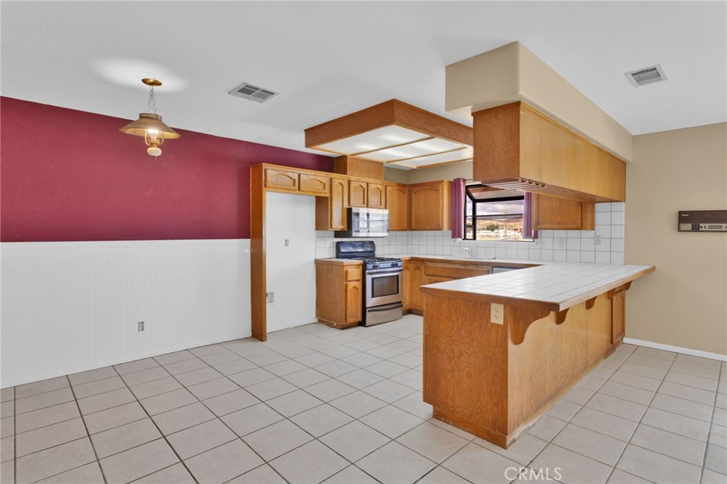 15160 Cheyenne Road Apple Valley, CA 92307 - Photo 12 of 55 a kitchen with stainless steel appliances a stove a sink and a refrigerator