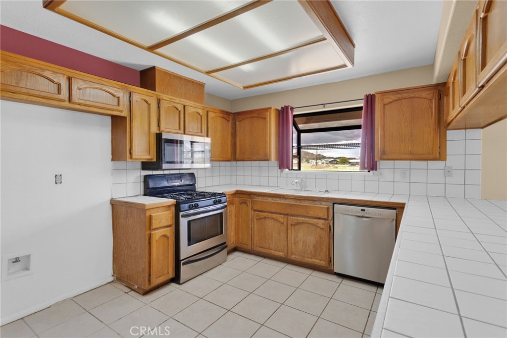 15160 Cheyenne Road Apple Valley, CA 92307 - Photo 14 of 55 a kitchen with stainless steel appliances granite countertop a sink and cabinets