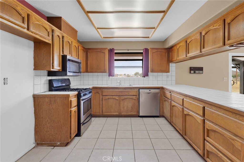 15160 Cheyenne Road Apple Valley, CA 92307 - Photo 15 of 55 a kitchen with a sink window and cabinets