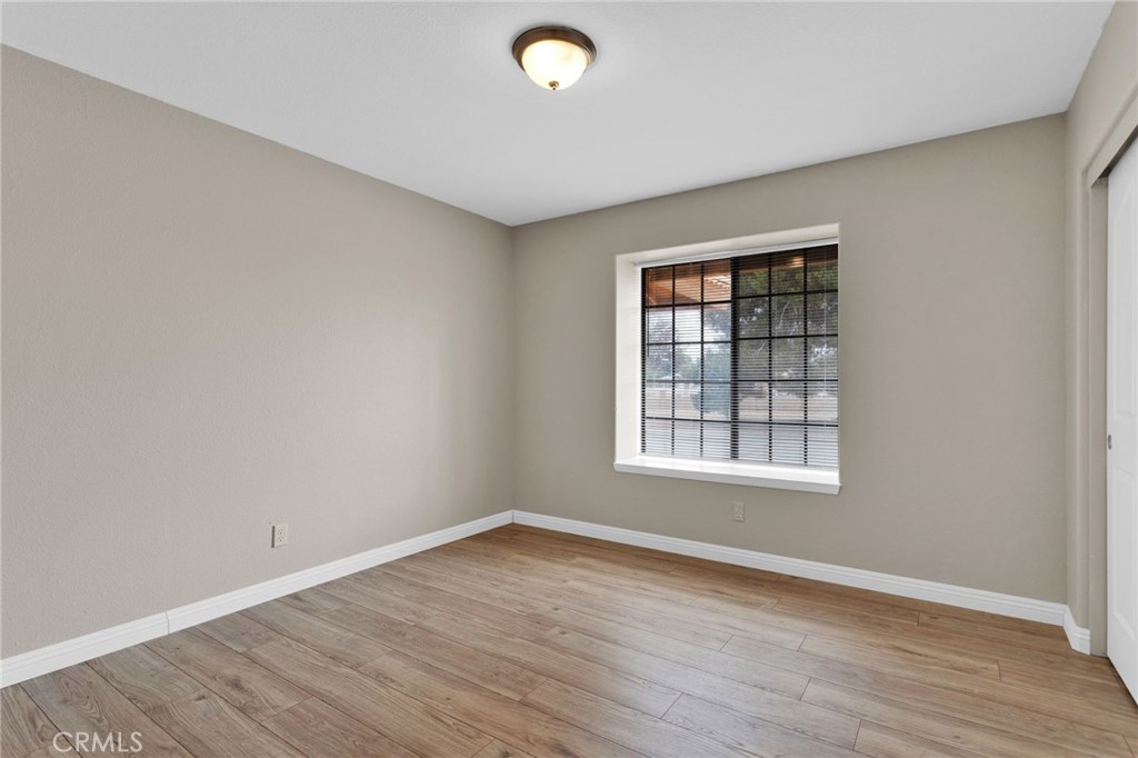 15160 Cheyenne Road Apple Valley, CA 92307 - Photo 22 of 55 an empty room with wooden floor and windows