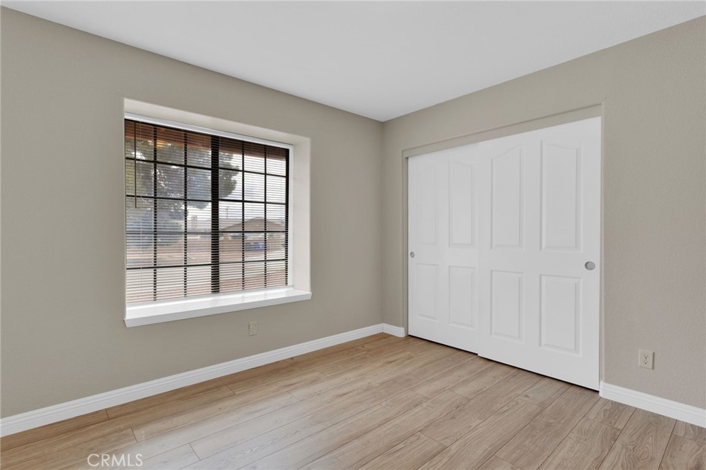 15160 Cheyenne Road Apple Valley, CA 92307 - Photo 23 of 55 a view of an empty room with wooden floor and a window