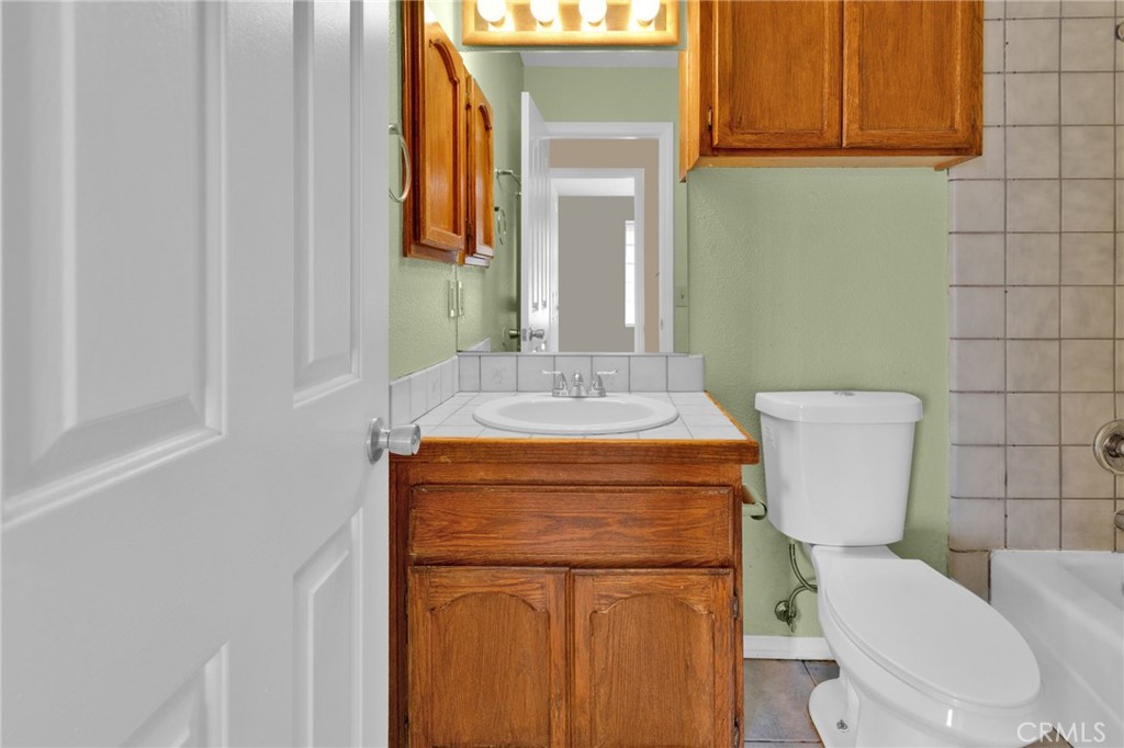 15160 Cheyenne Road Apple Valley, CA 92307 - Photo 25 of 55 a bathroom with a granite countertop toilet sink and mirror