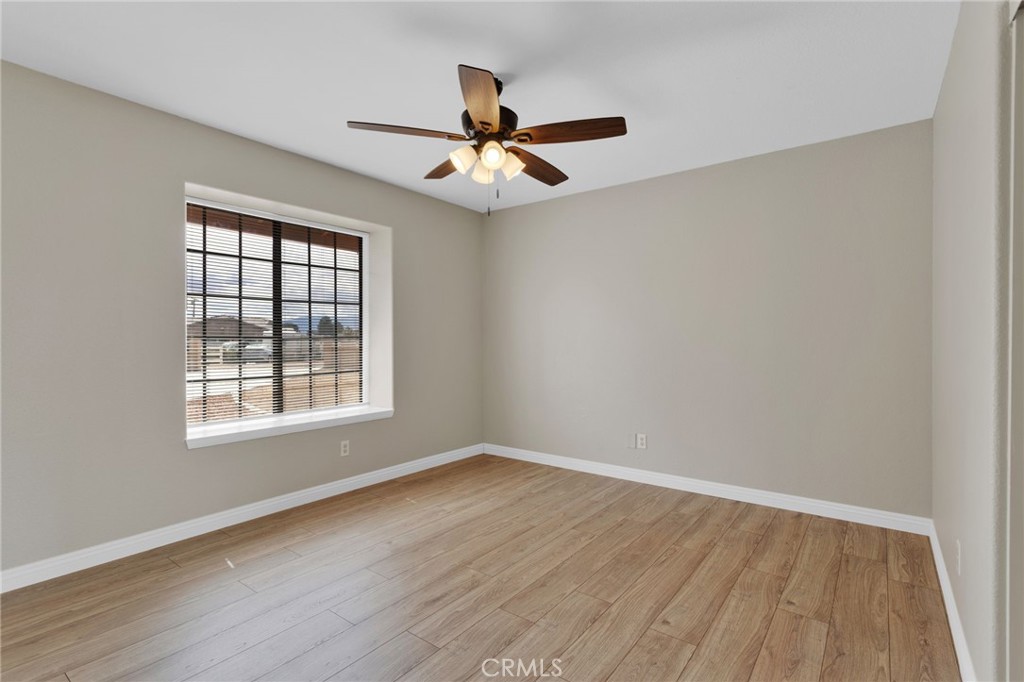 15160 Cheyenne Road Apple Valley, CA 92307 - Photo 26 of 55 an empty room with wooden floor fan and windows