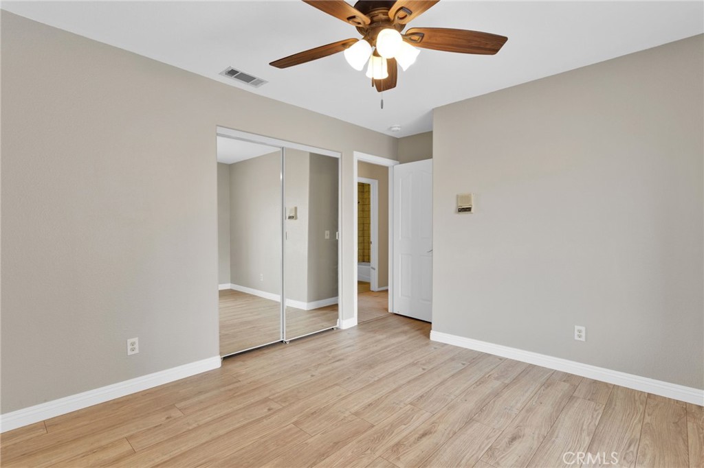 15160 Cheyenne Road Apple Valley, CA 92307 - Photo 27 of 55 an empty room with wooden floor and ceiling fan