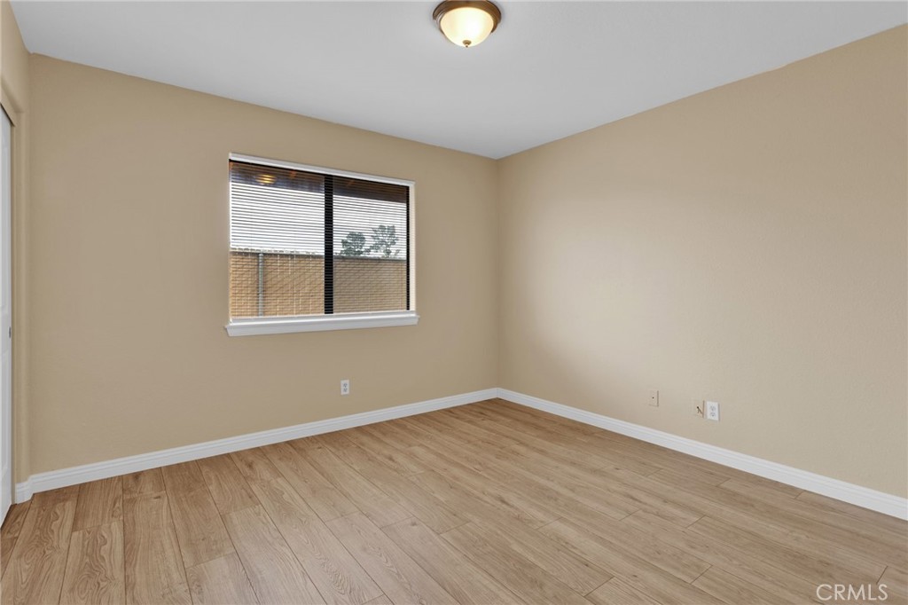 15160 Cheyenne Road Apple Valley, CA 92307 - Photo 28 of 55 a view of an empty room with wooden floor and a window