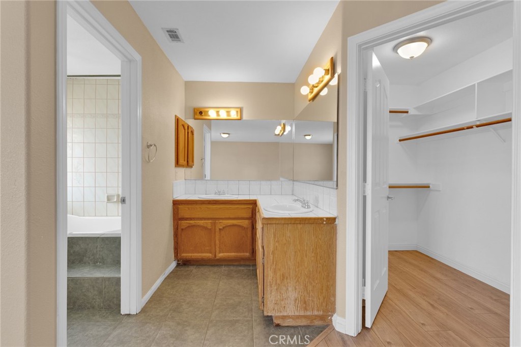 15160 Cheyenne Road Apple Valley, CA 92307 - Photo 32 of 55 a bathroom with a granite countertop sink a mirror and a shower