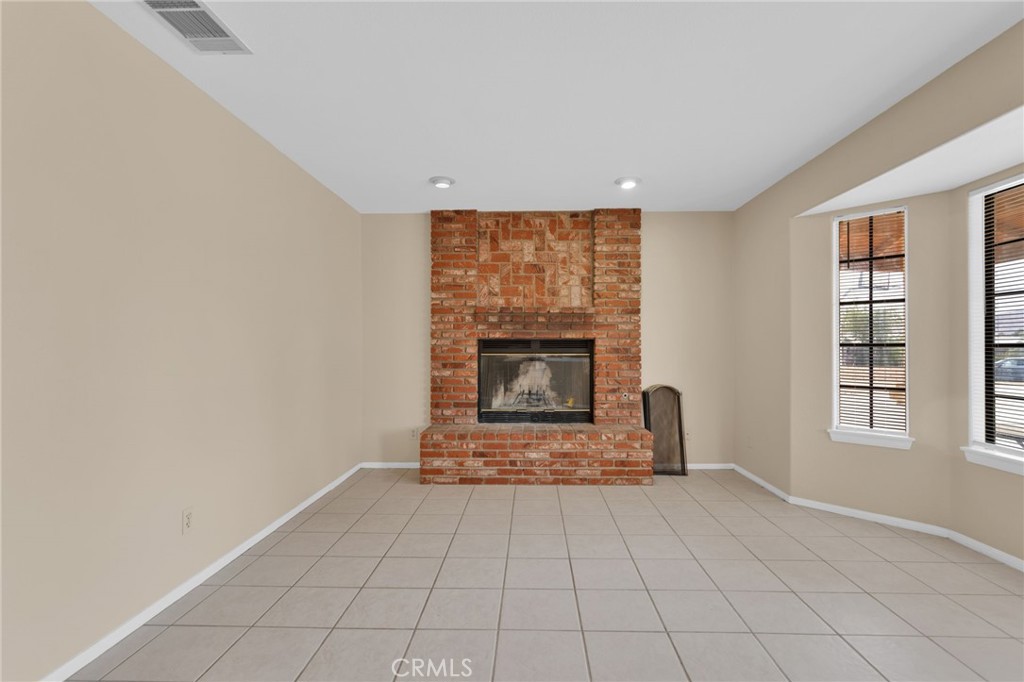 15160 Cheyenne Road Apple Valley, CA 92307 - Photo 4 of 55 an empty room with fireplace and windows