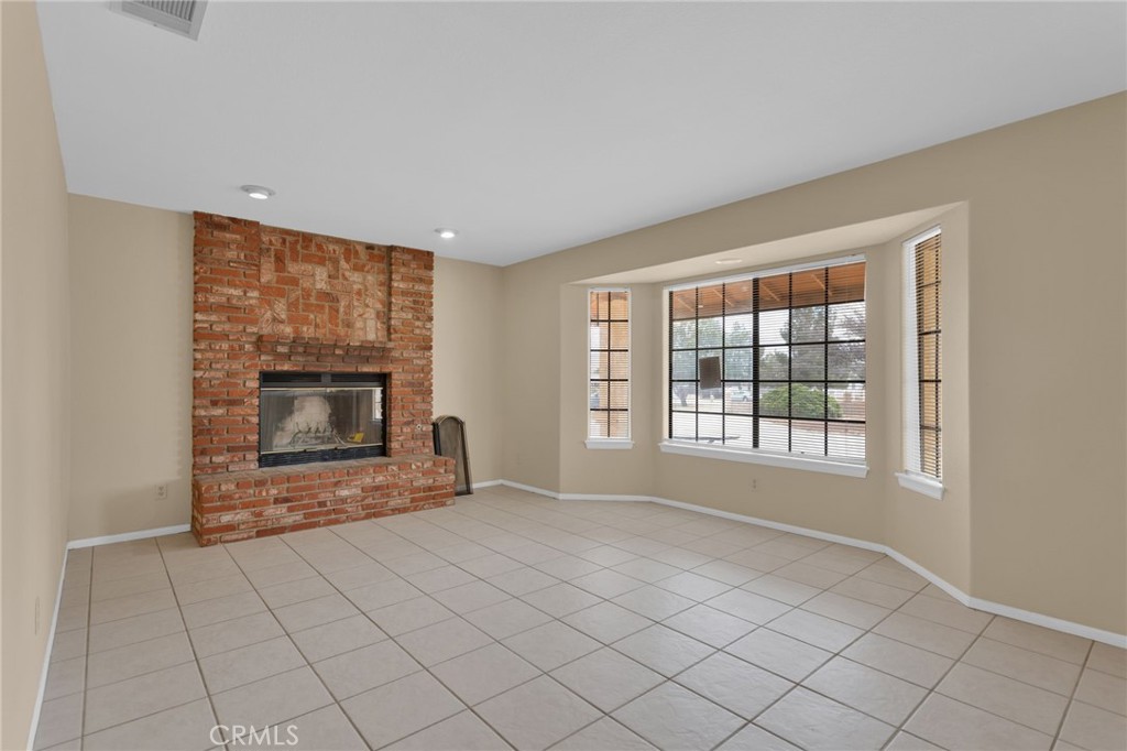 15160 Cheyenne Road Apple Valley, CA 92307 - Photo 5 of 55 a view of an empty room with a fireplace and a window