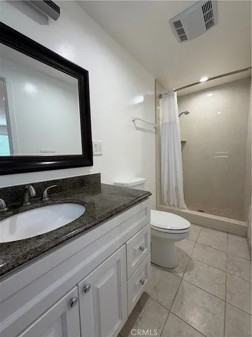 a bathroom with a granite countertop sink toilet and shower