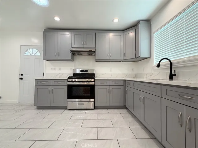 a kitchen with a sink a stove and cabinets