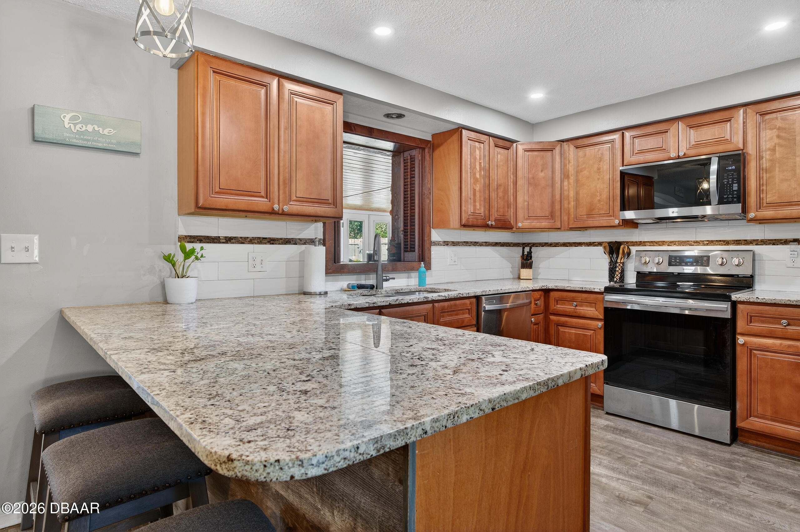 1010 Fernald Street Edgewater, FL 32132 - Photo 11 of 43 a kitchen with granite countertop a sink a stove and a wooden cabinets
