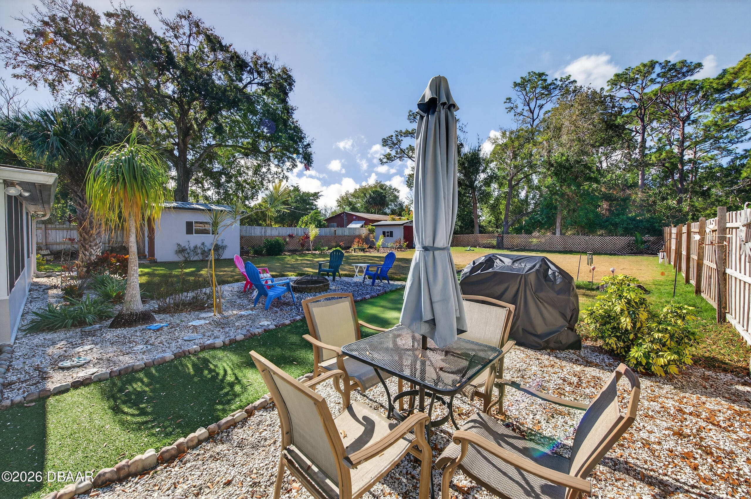 1010 Fernald Street Edgewater, FL 32132 - Photo 34 of 43 a view of a patio with table and chairs potted plants and palm tree