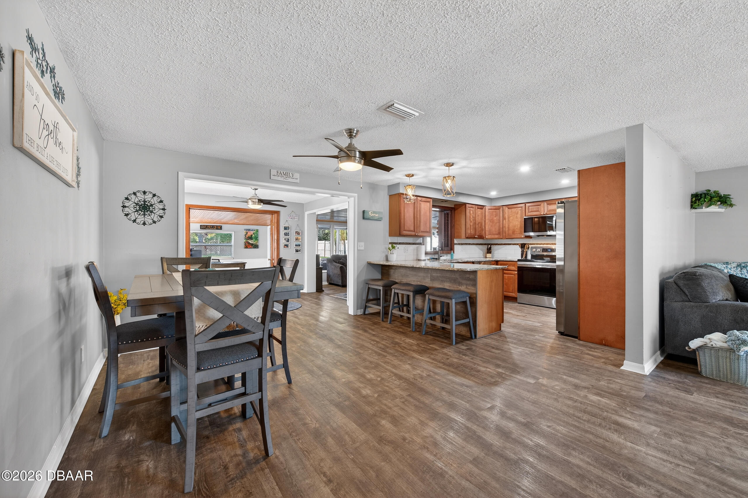 1010 Fernald Street Edgewater, FL 32132 - Photo 9 of 43 a kitchen with stainless steel appliances kitchen island granite countertop a dining table chairs and a refrigerator