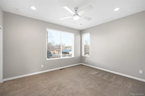 an empty room with closet and a ceiling fan