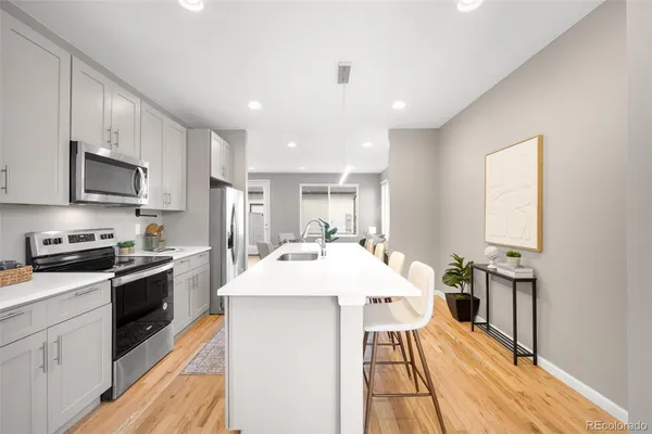 a kitchen with stainless steel appliances granite countertop a sink stove and refrigerator