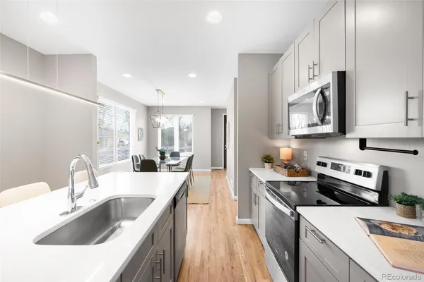 a kitchen with stainless steel appliances granite countertop a stove and a white cabinets