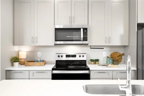 a kitchen with refrigerator a stove a dining table and chairs