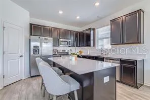 a kitchen with stainless steel appliances granite countertop a stove a sink a refrigerator a microwave and cabinets