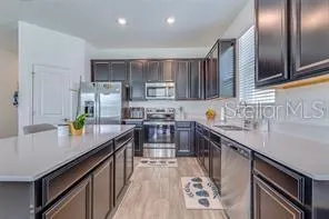 a kitchen with stainless steel appliances granite countertop a sink stove and refrigerator