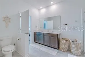 a spacious bathroom with a granite countertop sink a toilet and a mirror
