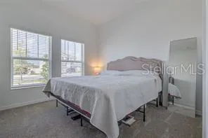 a bed sitting in a bedroom next to a window