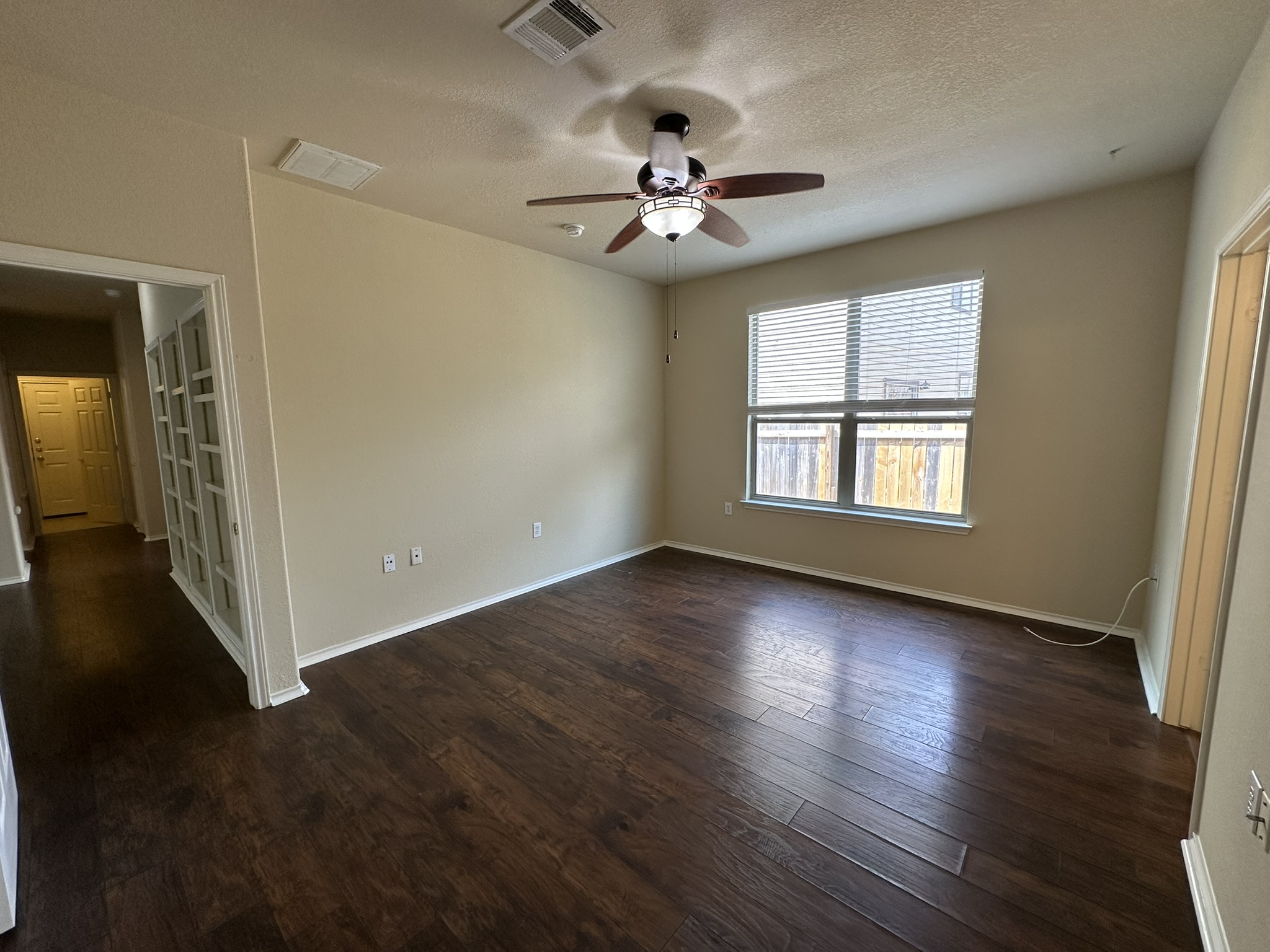 4507 Peach Grove Road Austin, TX 78744 - Photo 15 of 35 Warm wood flooring grounds this versatile living space highlighted by large windows.