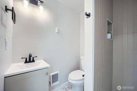 a bathroom with a sink toilet and a mirror