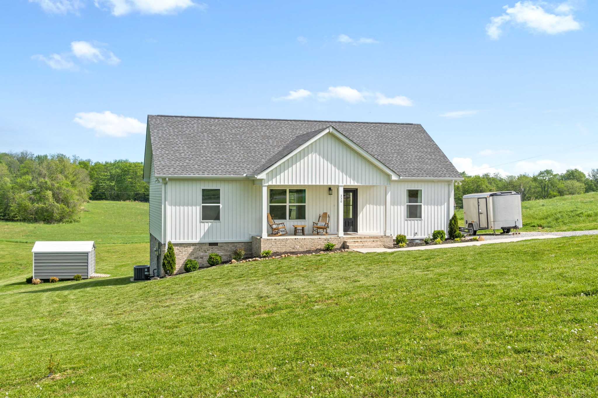 330 Woodruff Road Adams, TN 37010 - Photo 4 of 31 a front view of a house with a garden and yard