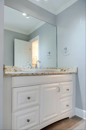 a bathroom with a sink vanity granite and a mirror
