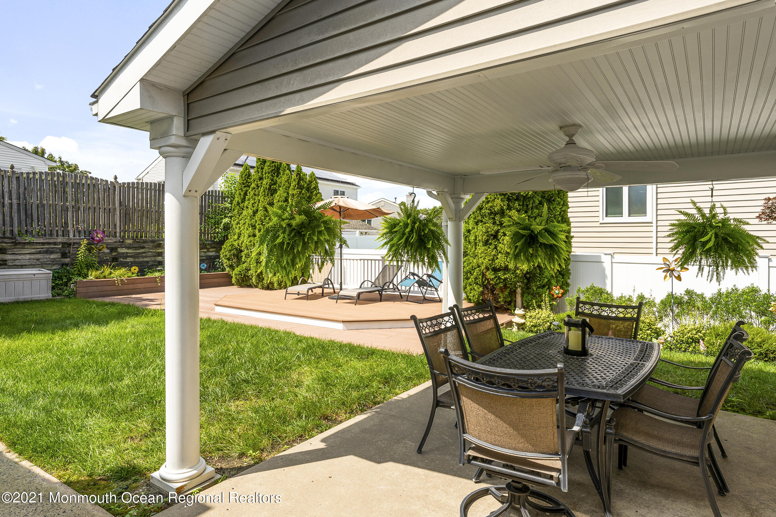 808 Constitution Drive Brick, NJ 08724 - Photo 19 of 27 a view of a patio with table and chairs potted plants with wooden floor and fence
