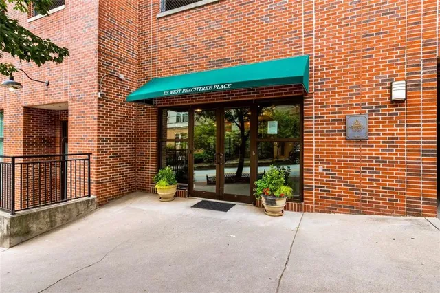 a living room with couches and potted plants with wooden floor