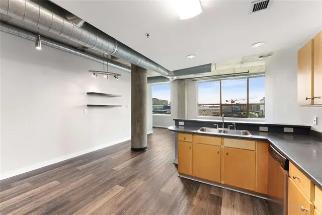 a view of a kitchen with wooden floor and a sink