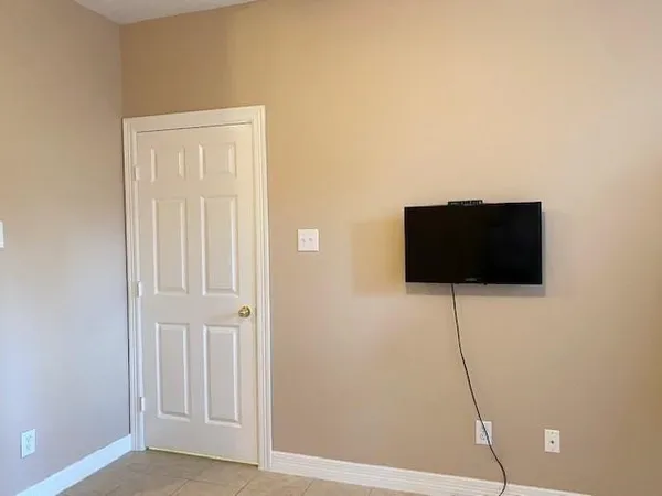 a living room that has a flat screen tv and a floor to ceiling window