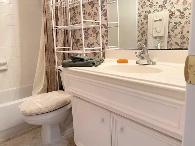 a bathroom with a granite countertop toilet and a sink