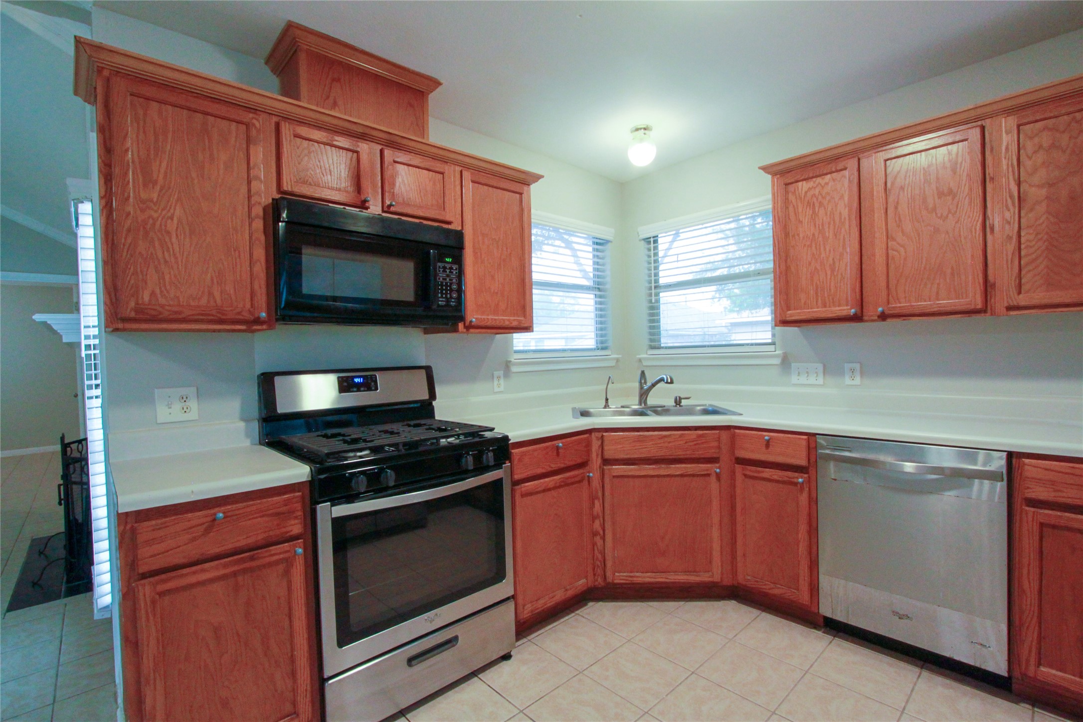 14708 Highsmith Street Austin, TX 78725 - Photo 12 of 28 Kitchen with stainless steel appliances, light countertops, and wood finish cabinetry