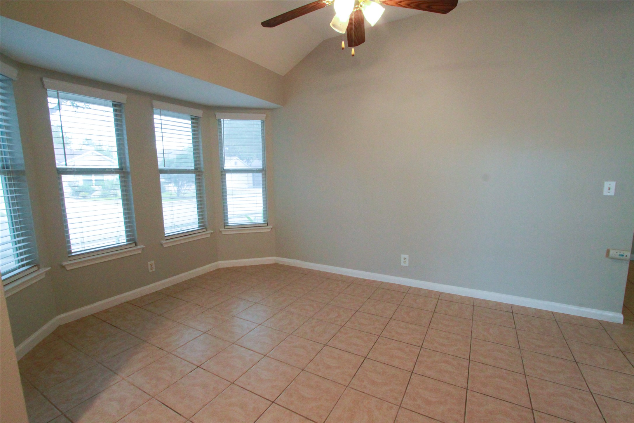 14708 Highsmith Street Austin, TX 78725 - Photo 14 of 28 Empty room featuring a ceiling fan, vaulted ceiling, and light tile patterned floors