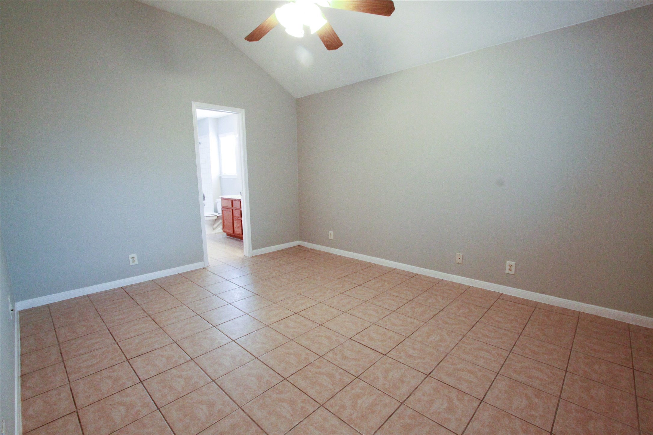 14708 Highsmith Street Austin, TX 78725 - Photo 16 of 28 Unfurnished room featuring ceiling fan, light tile patterned flooring, and vaulted ceiling