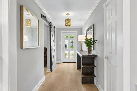 a view of a hallway with furniture and a potted plant
